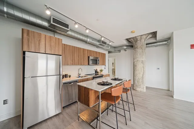 a kitchen with stainless steel appliances a refrigerator and a stove top oven