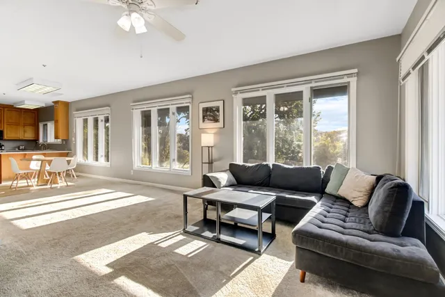 a kitchen with stainless steel appliances granite countertop a stove top oven a sink a dining table and chairs