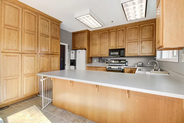 a bed sitting in a spacious bedroom next to a window