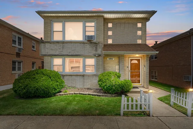 a view of a brick house with a yard