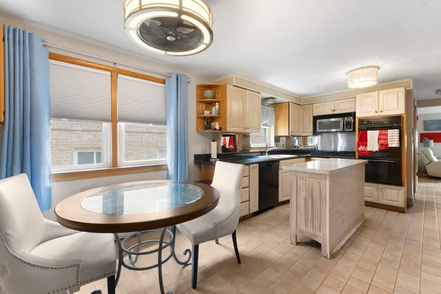 a kitchen with a table chairs sink and cabinets