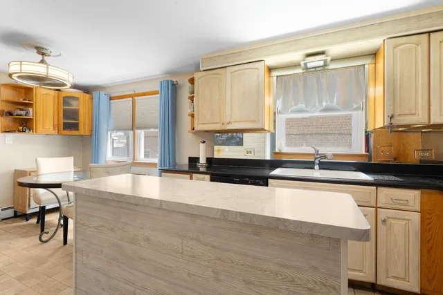 a large kitchen with granite countertop a sink and a counter top space