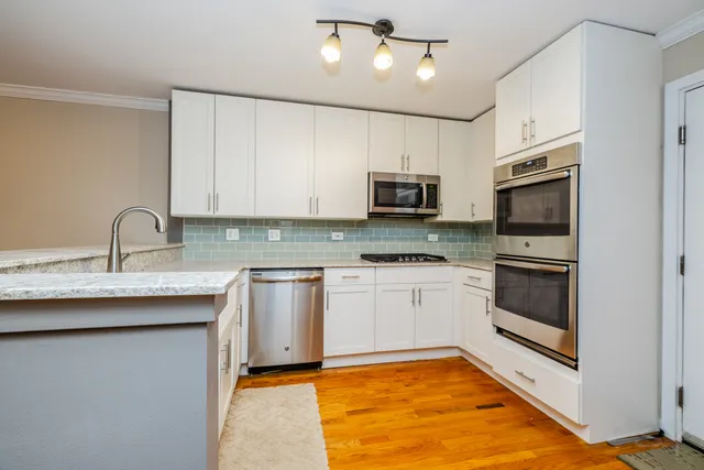 a kitchen with granite countertop a sink and cabinets