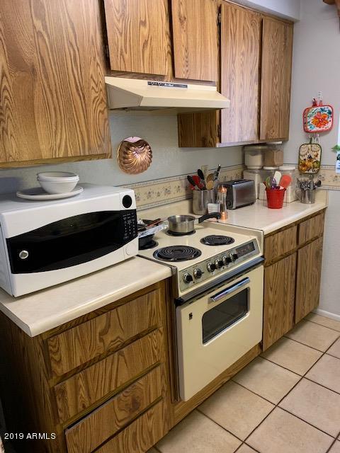 99 North Cooper Road, Unit 136 Chandler, AZ 85225 - Photo 11 of 19 a kitchen with stainless steel appliances a stove and a microwave