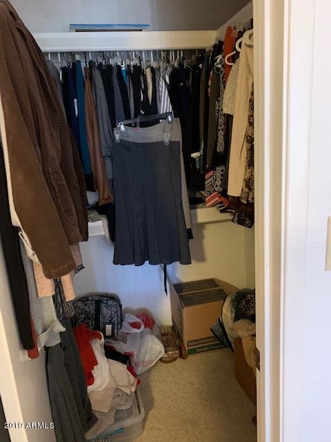 99 North Cooper Road, Unit 136 Chandler, AZ 85225 - Photo 14 of 19 a view of walk in closet with clothes and shoes