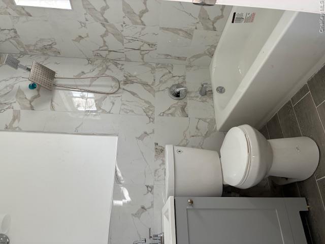 56 Ash Street Central Islip, NY 11722 - Photo 13 of 14 Bathroom with vanity, a combined bath / shower with marble appearance, and tile walls