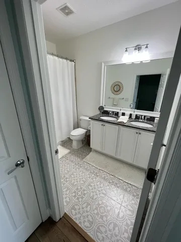 a view of bathroom with a sink mirror and toilet