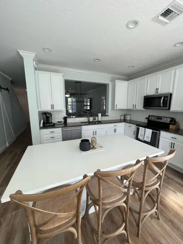 a kitchen with a table chairs a sink a stove a microwave and cabinets