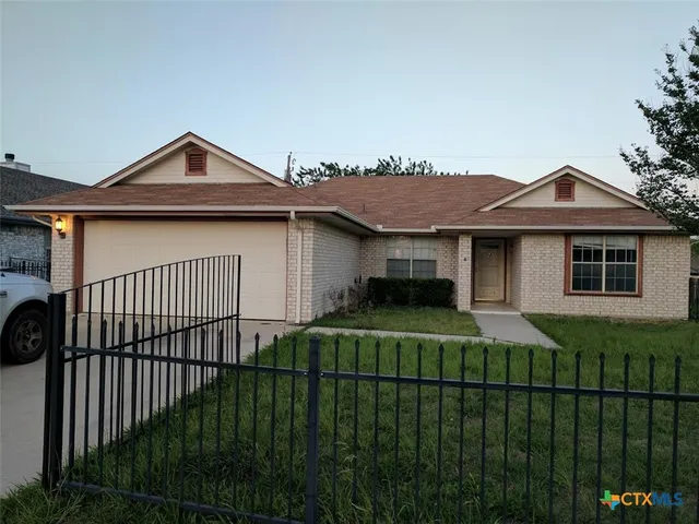 a front view of a house with yard and green space