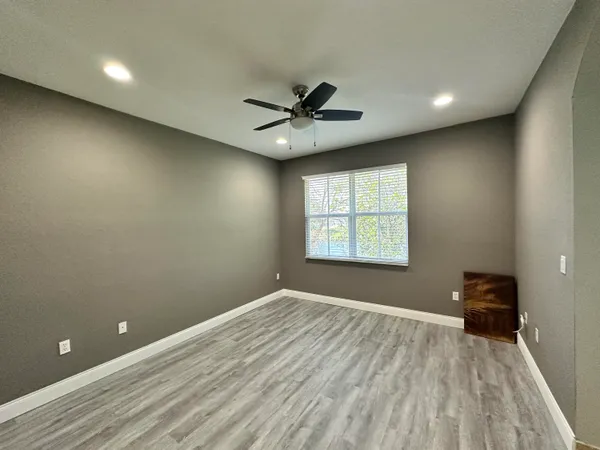 an empty room with a window and a fan