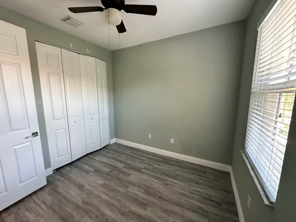 an empty room with wooden floor and window