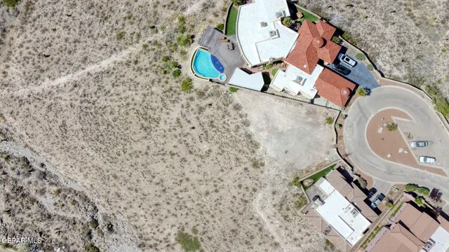 an aerial view of a house with swimming pool and large trees