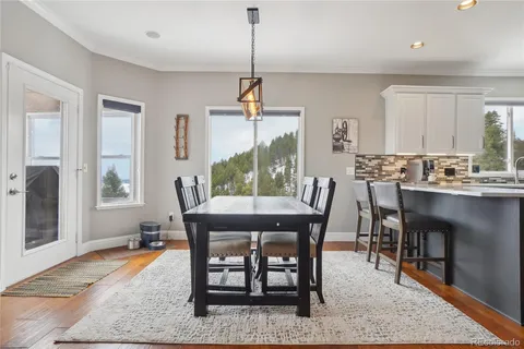 a dining room with furniture a rug and wooden floor