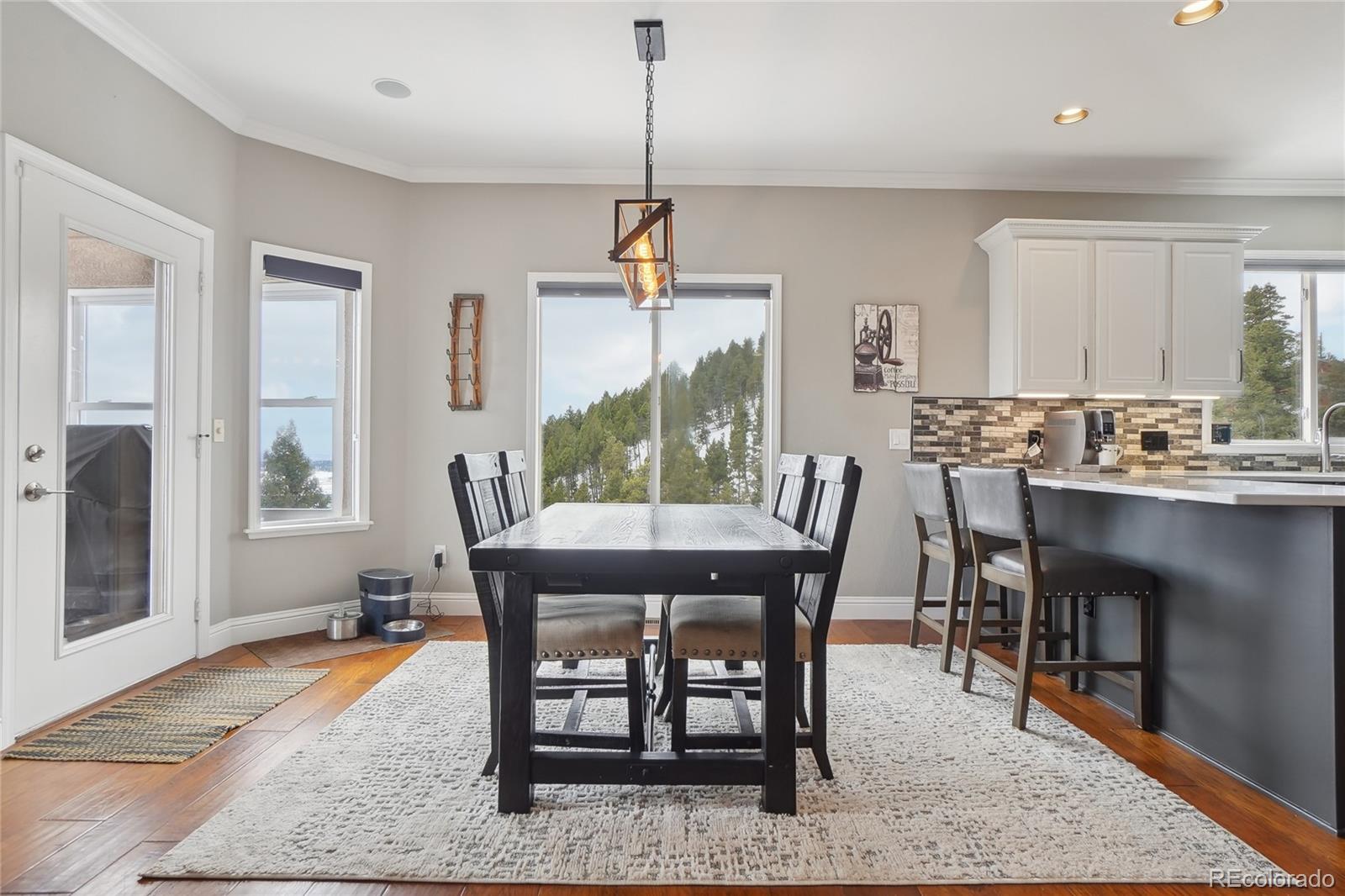 13084 Deer Ridge Way Larkspur, CO 80118 - Photo 11 of 48 a dining room with furniture a rug and wooden floor