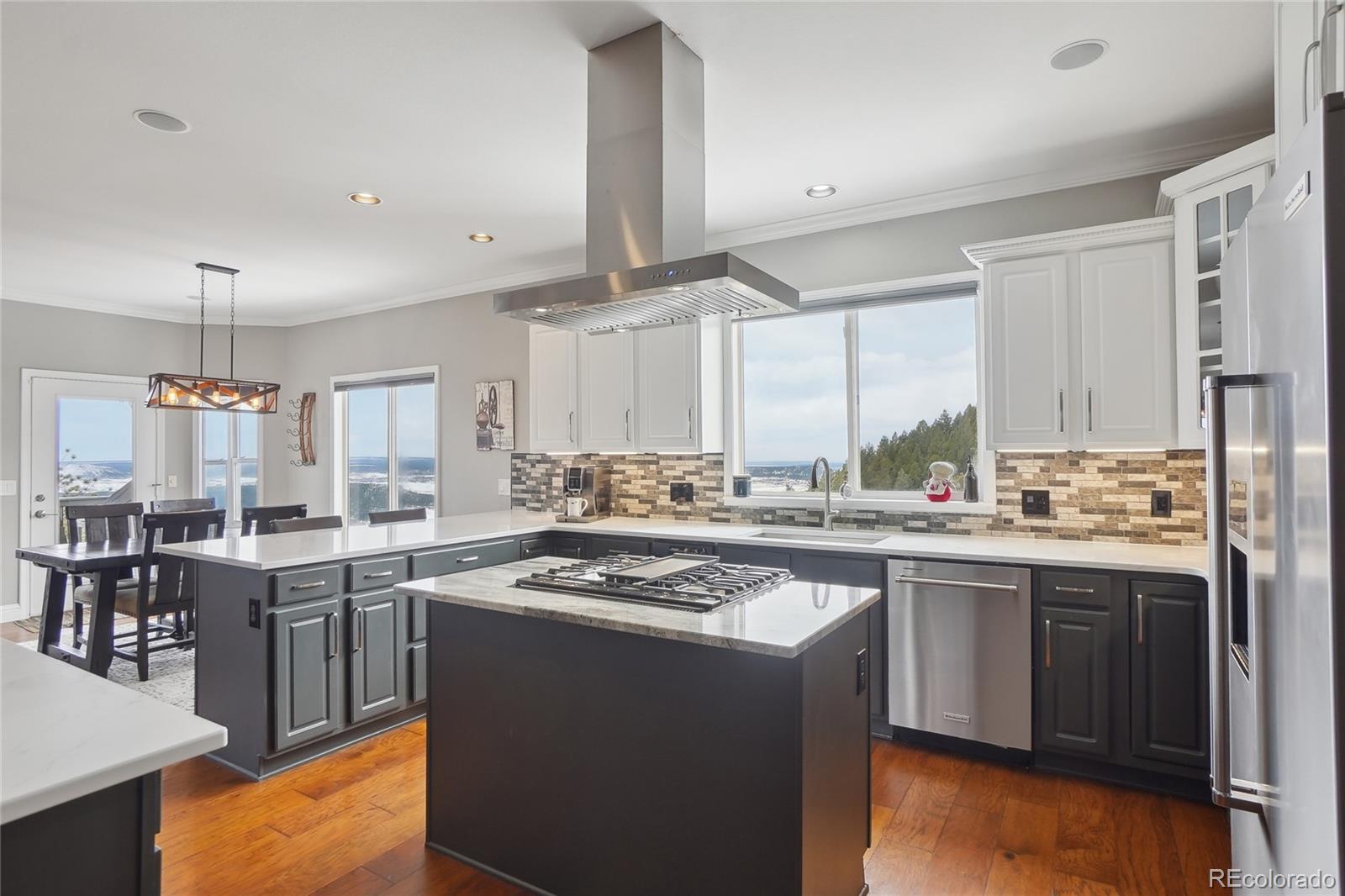 13084 Deer Ridge Way Larkspur, CO 80118 - Photo 13 of 48 a kitchen with a stove a sink a refrigerator and chairs