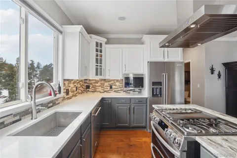 a kitchen with stainless steel appliances granite countertop a sink stove and refrigerator