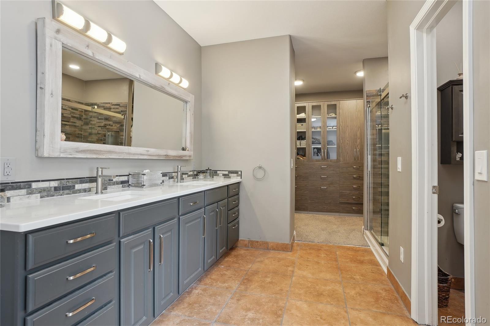 13084 Deer Ridge Way Larkspur, CO 80118 - Photo 20 of 48 a bathroom with a sink a shower a mirror and a bathtub