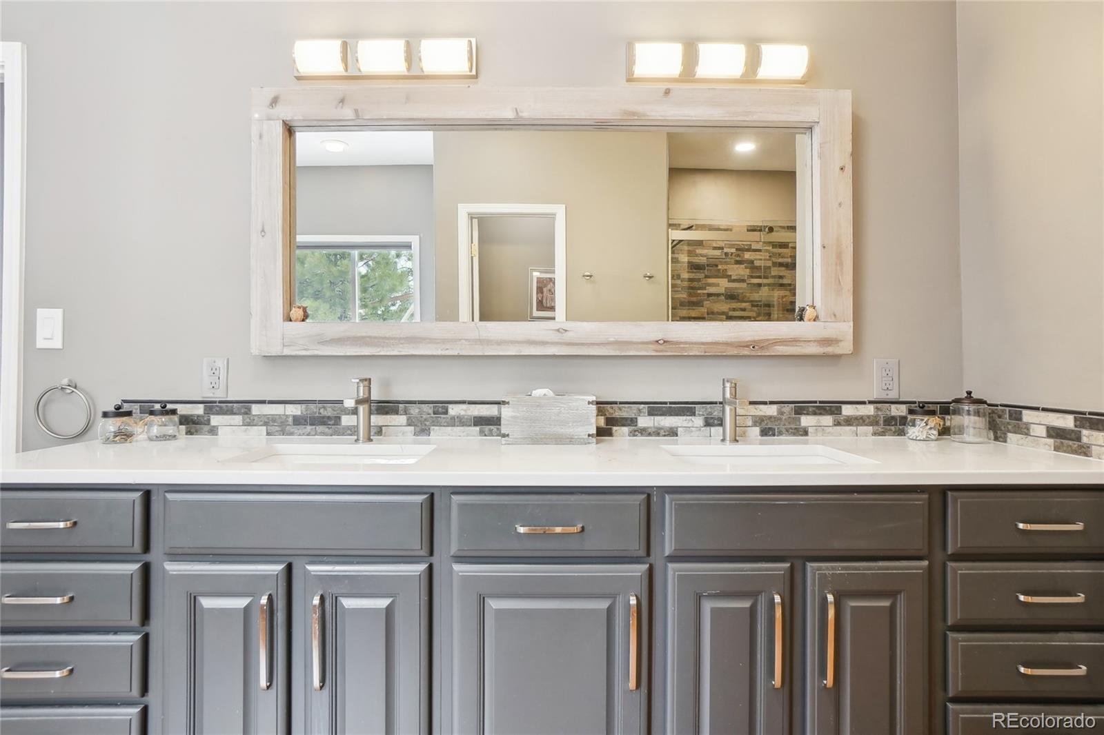 13084 Deer Ridge Way Larkspur, CO 80118 - Photo 21 of 48 a bathroom with a sink vanity and a mirror