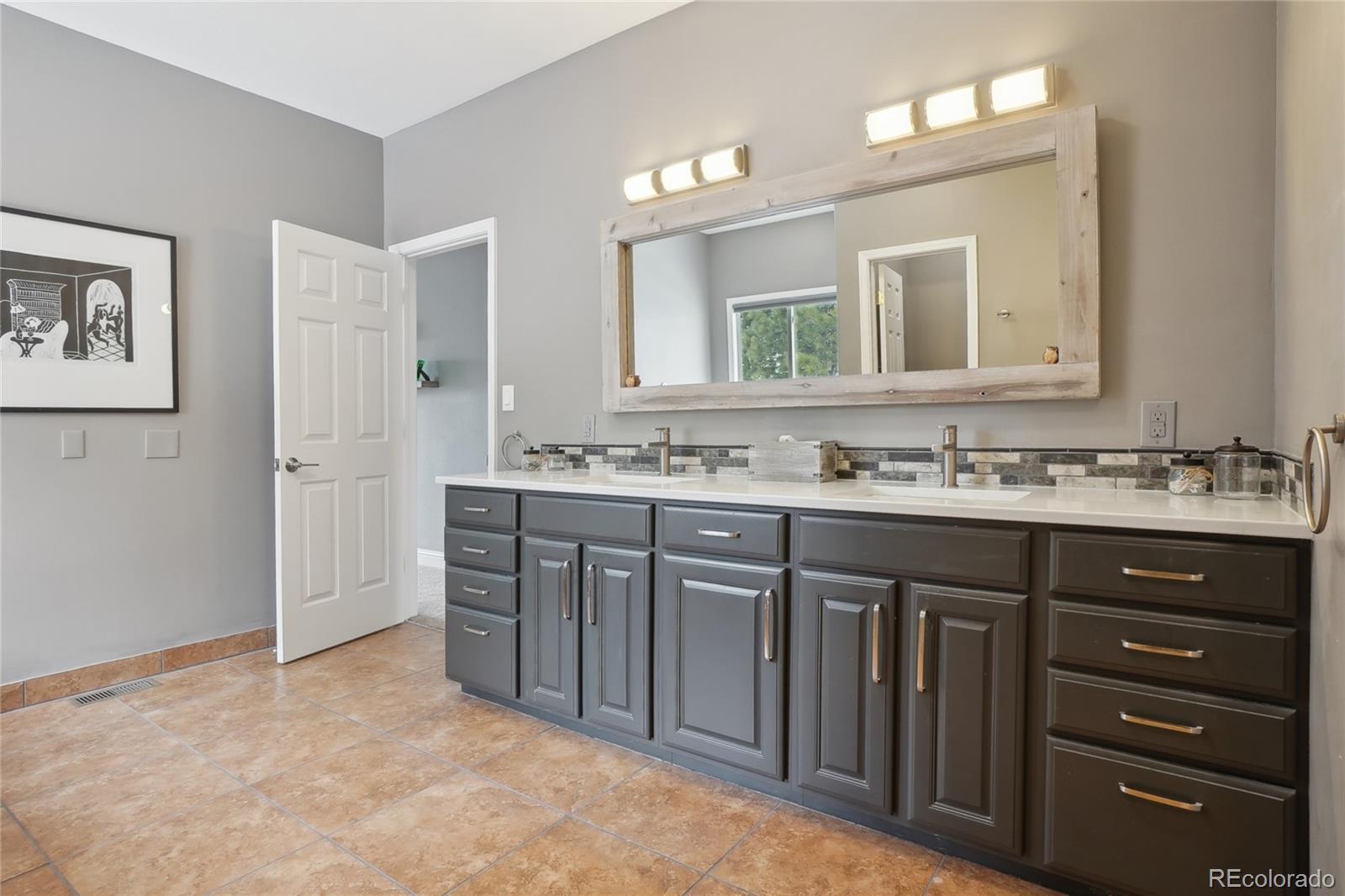 13084 Deer Ridge Way Larkspur, CO 80118 - Photo 24 of 48 a bathroom with a sink vanity and a mirror