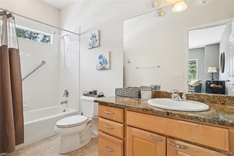 a bathroom with a granite countertop sink toilet and shower