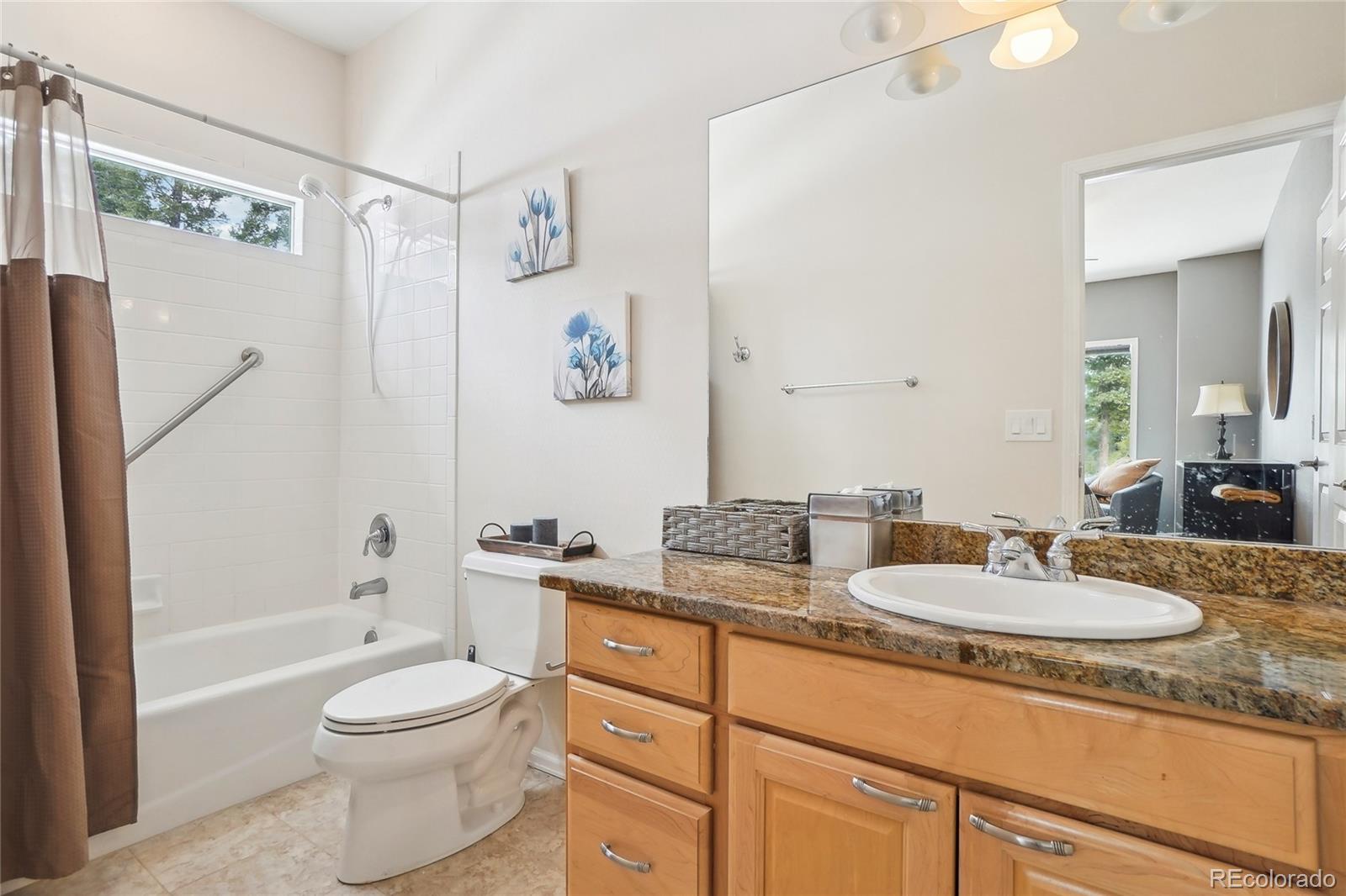 13084 Deer Ridge Way Larkspur, CO 80118 - Photo 28 of 48 a bathroom with a granite countertop sink toilet and shower