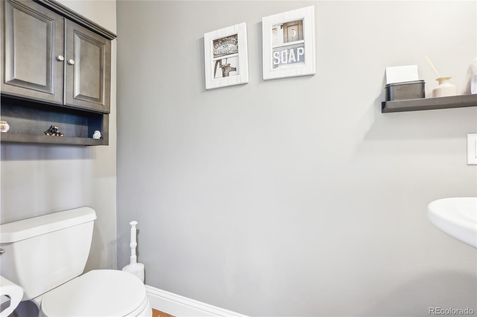 13084 Deer Ridge Way Larkspur, CO 80118 - Photo 33 of 48 a white toilet sitting next to a bathroom sink