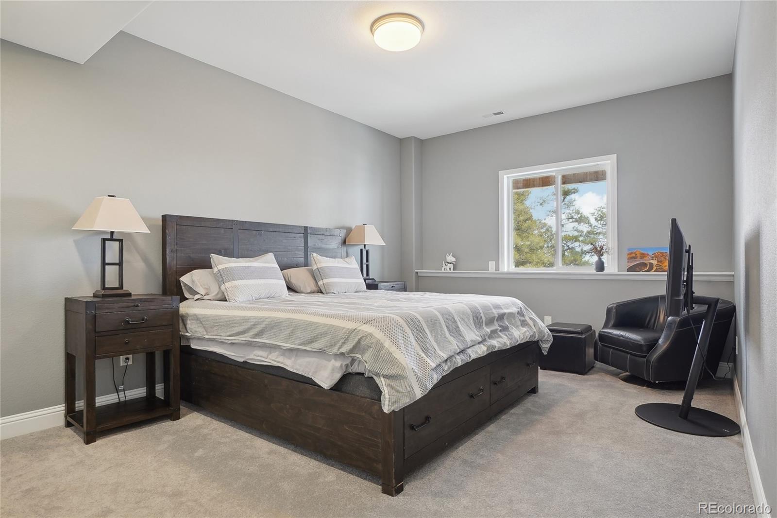 13084 Deer Ridge Way Larkspur, CO 80118 - Photo 34 of 48 a bed room with a bed and a chair