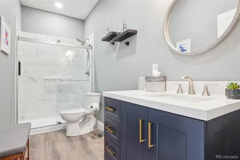 a bathroom with a sink a toilet and shower