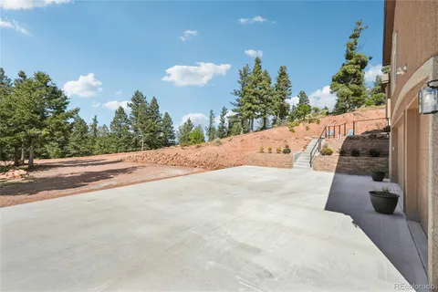 a view of a white house with a yard and potted plants