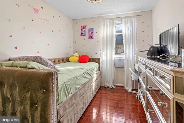 a bedroom with a bed and a flat tv screen on the dresser