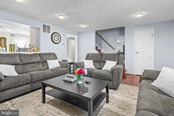 a living room with furniture and wooden floor