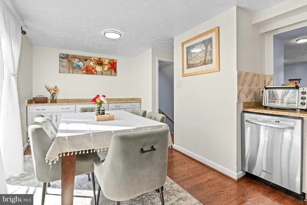 a view of a kitchen area with furniture and wooden floor