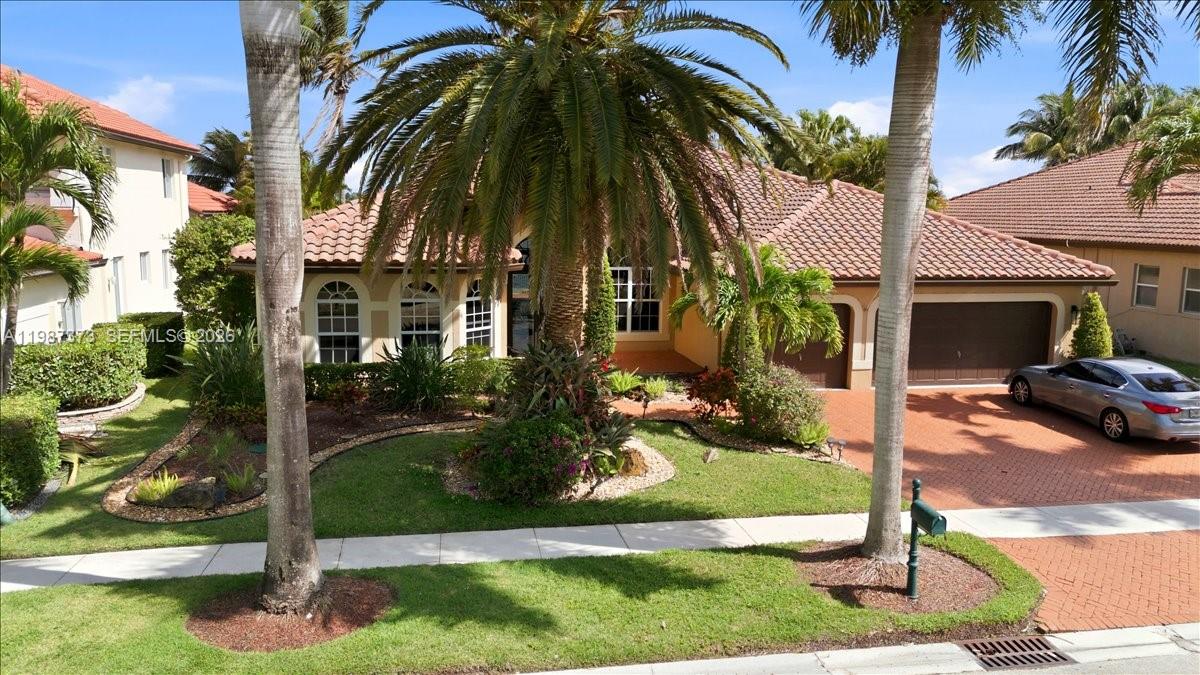 18631 Southwest 39th Street Miramar, FL 33029 - Photo 2 of 23 front view of house with a yard and palm trees