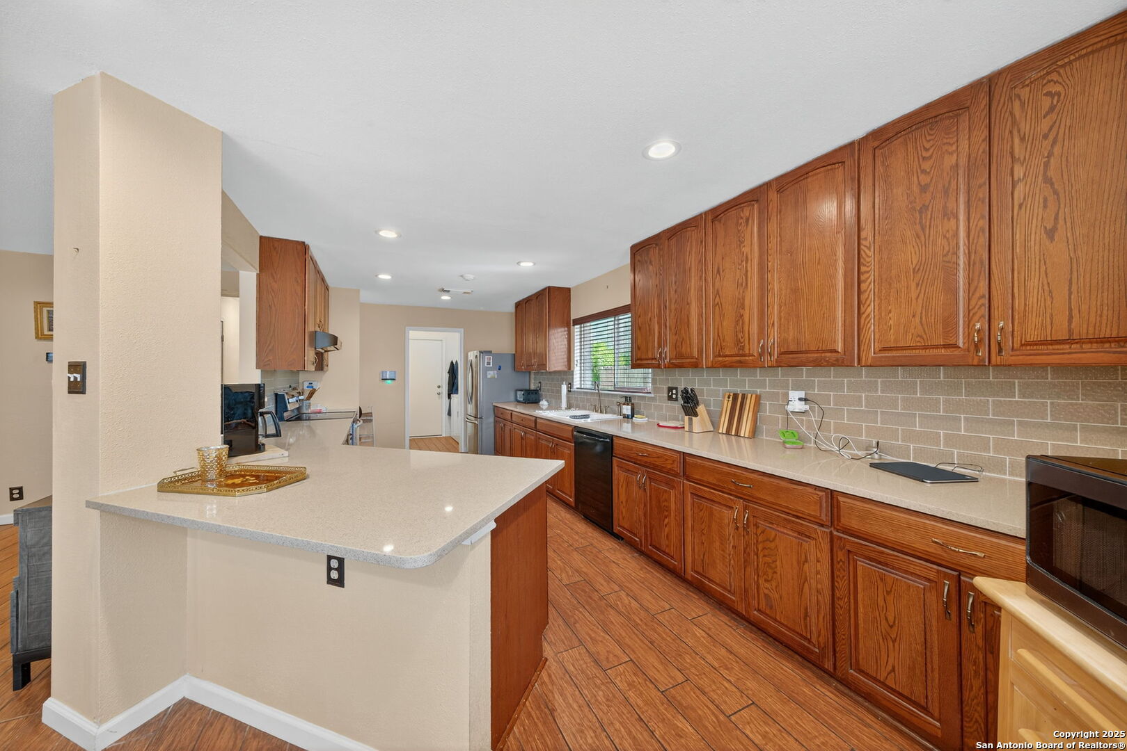 1902 Indian Meadows Drive San Antonio, TX 78230 - Photo 10 of 31 a kitchen with stainless steel appliances kitchen island granite countertop wooden cabinets a stove and a sink