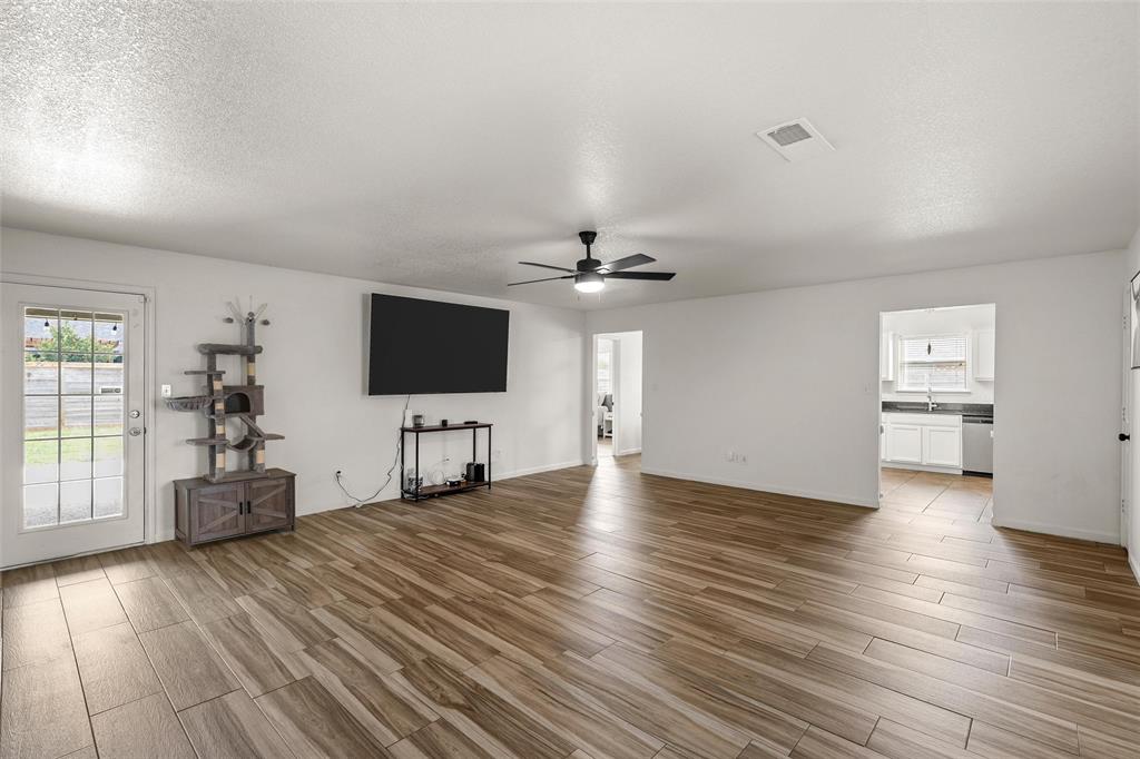 4209 Rance Lane Waco, TX 76708 - Photo 3 of 26 an empty room with windows flat screen tv and wooden floor