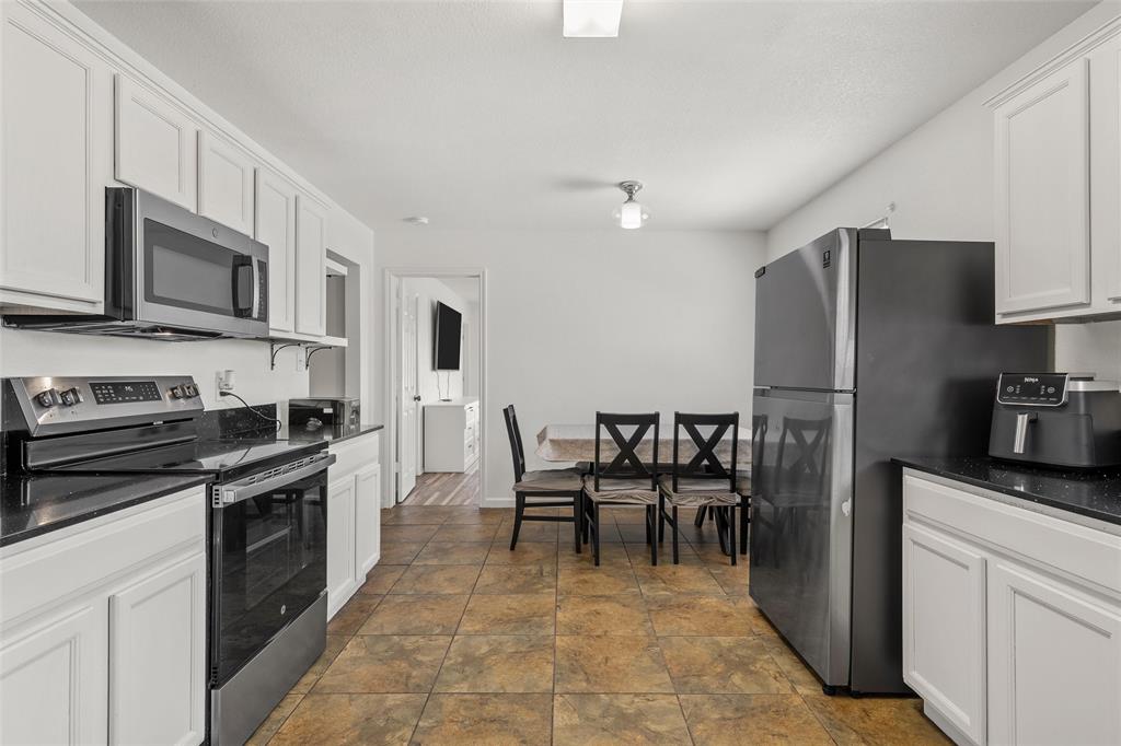 4209 Rance Lane Waco, TX 76708 - Photo 4 of 26 a kitchen with stainless steel appliances granite countertop a stove top oven a refrigerator a stove top oven and a center island