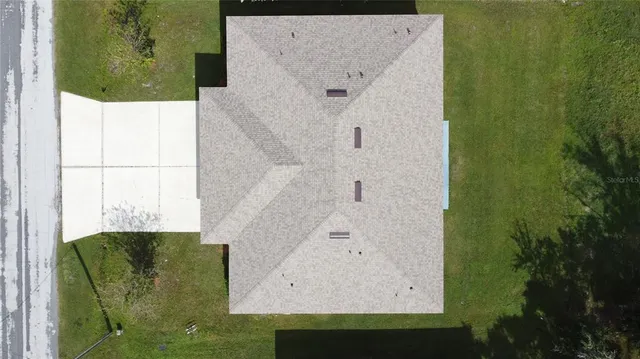 an aerial view of a house with garden space and street view