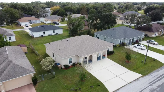 a view of an empty room with window and chandelier fan