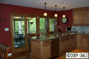 31003 Executive Point Tega Cay, SC 29708 - Photo 2 of 8 a kitchen with stainless steel appliances granite countertop a stove a sink dishwasher and a dining table with garden view