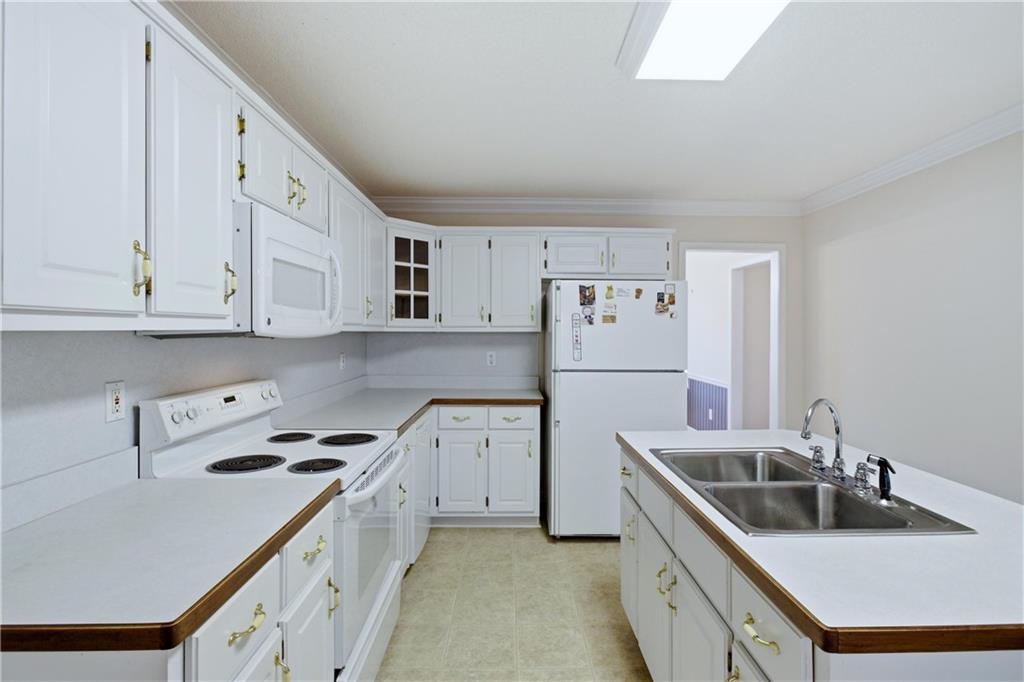 190 Cambridge Way Covington, GA 30016 - Photo 11 of 51 a kitchen with stainless steel appliances granite countertop a sink stove and refrigerator