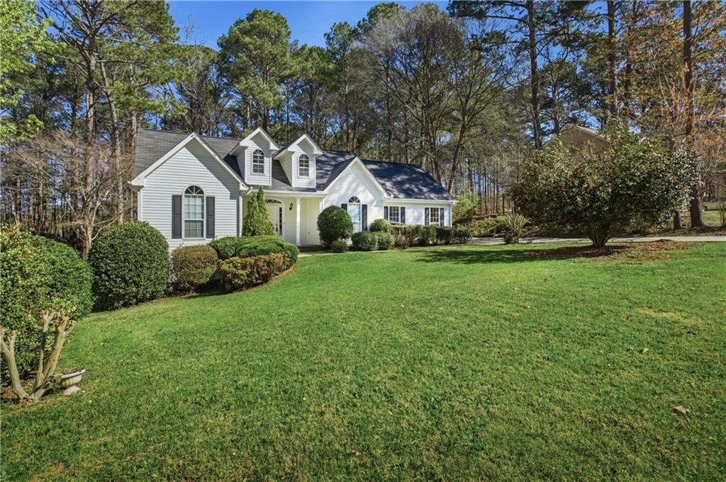 190 Cambridge Way Covington, GA 30016 - Photo 2 of 51 a front view of a house with a garden and trees