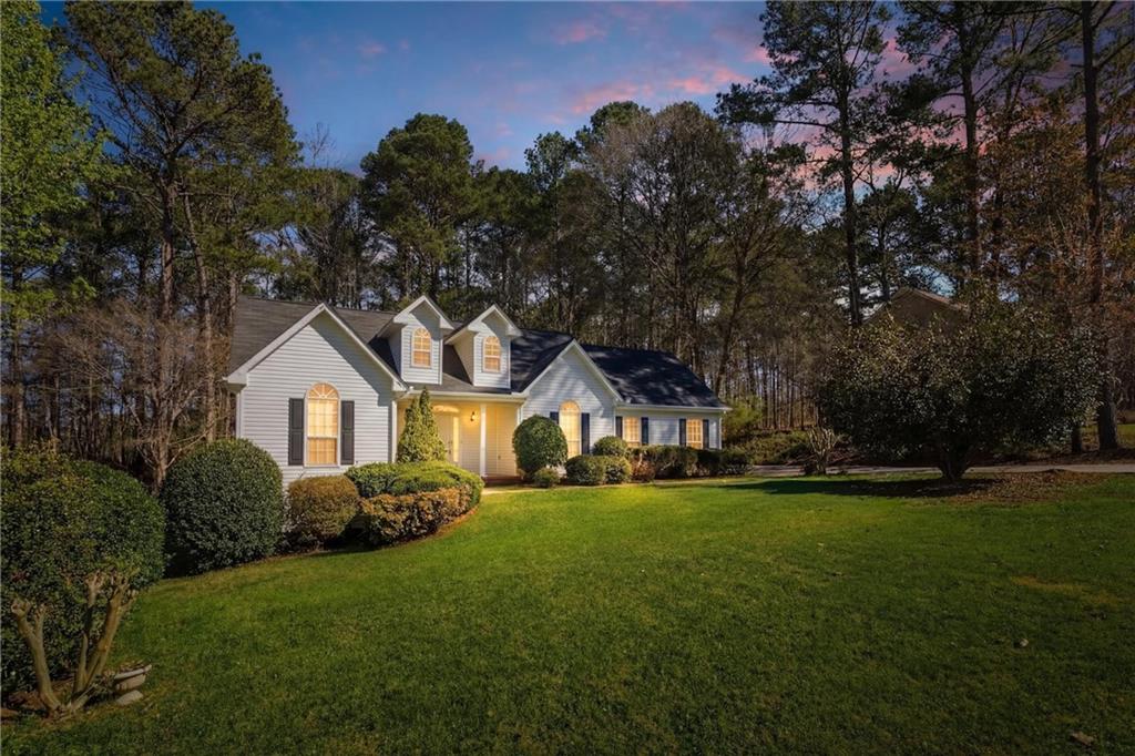 190 Cambridge Way Covington, GA 30016 - Photo 3 of 51 a front view of a house with a garden and trees