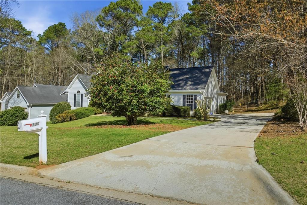 190 Cambridge Way Covington, GA 30016 - Photo 46 of 51 front view of house with a yard and trees all around