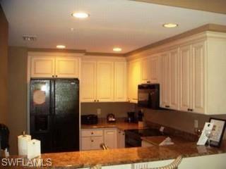 221 9th Street South, Unit 224 Naples, FL 34102 - Photo 6 of 8 a kitchen with refrigerator and window