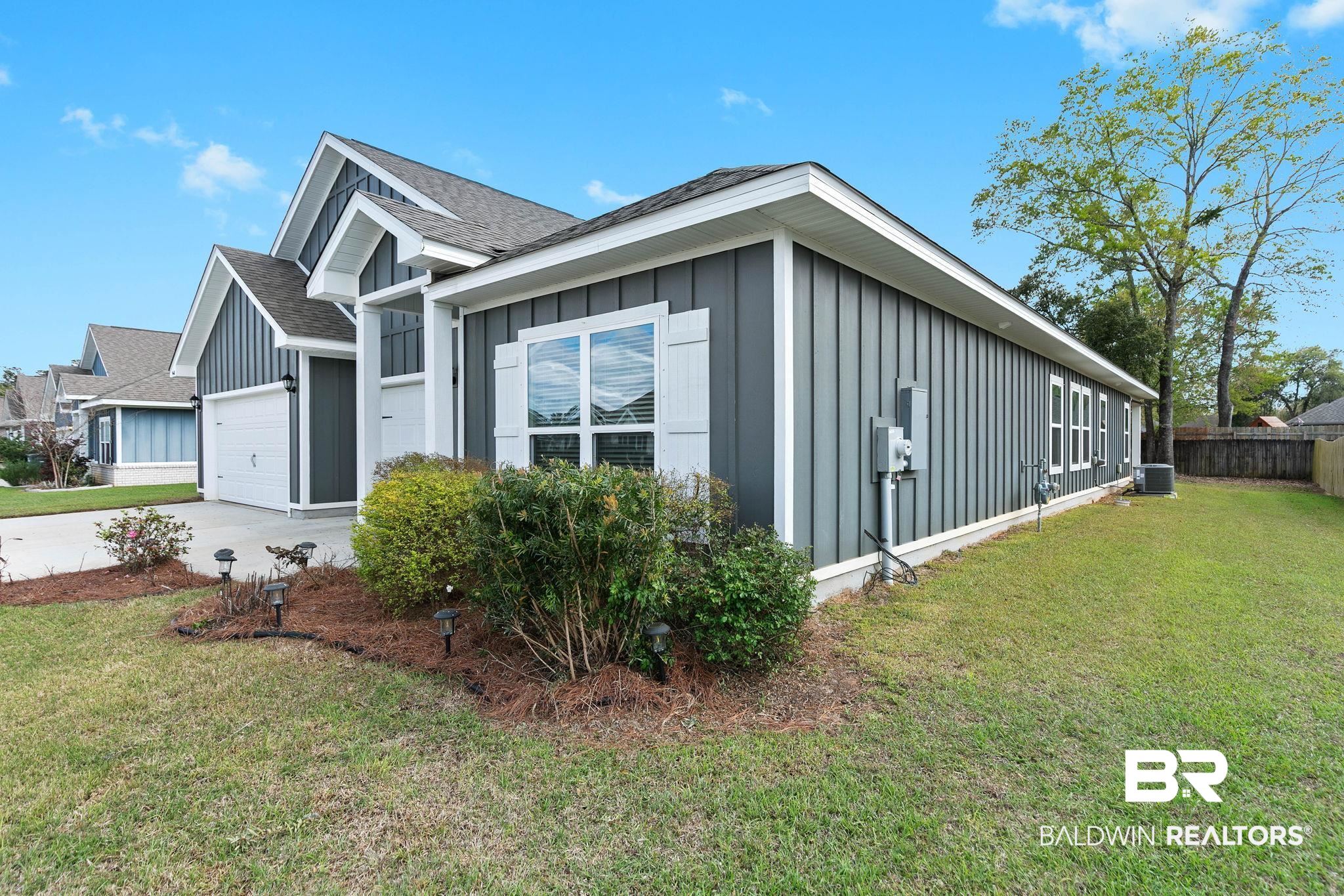 9448 Amethyst Drive Daphne, AL 36526 - Photo 51 of 61 View of side of home featuring board and batten siding, a shingled roof, a garage, and driveway