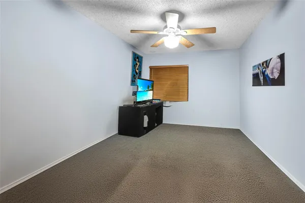 an empty room with a window and a ceiling fan