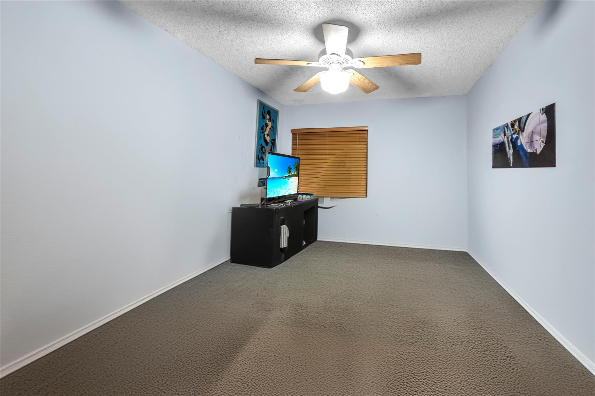 22349 Treetop Circle Boca Raton, FL 33433 - Photo 17 of 36 an empty room with a window and a ceiling fan