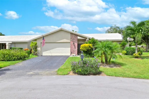 a front view of a house with a yard and a garage