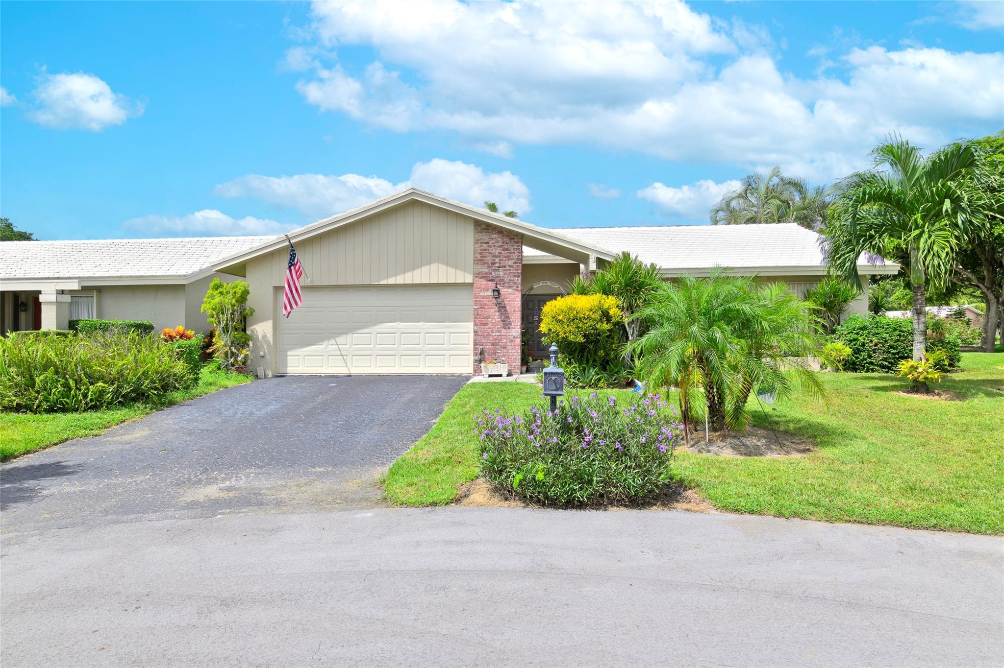 22349 Treetop Circle Boca Raton, FL 33433 - Photo 2 of 36 a front view of a house with a yard and a garage