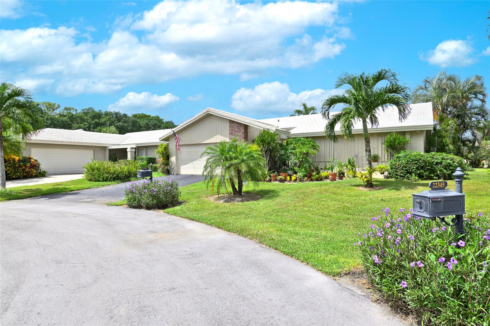 22349 Treetop Circle Boca Raton, FL 33433 - Photo 3 of 36 a view of a house with a yard and potted plants